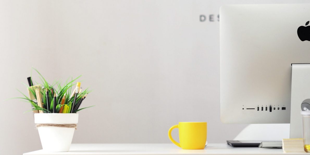 georgie-cobbs-459520-unsplash branding page header image. Creative studio desk with planet, coffee cup and plant pencil pot