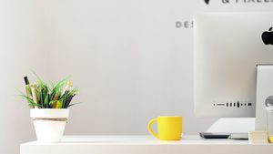 branding page header image. Creative studio desk with planet, coffee cup and plant pencil pot