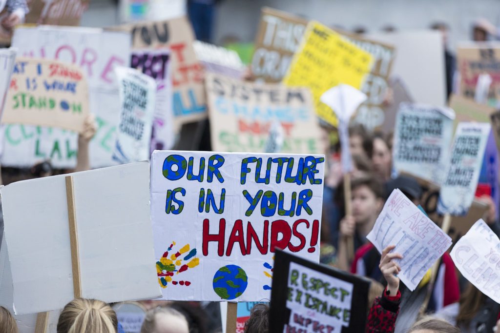 climate strike body image 2 signs in the middle of a protest