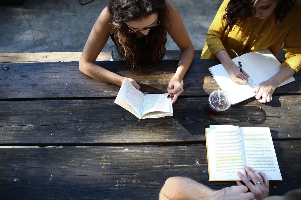 positive climate action people talking and reading books, sharing ideas.