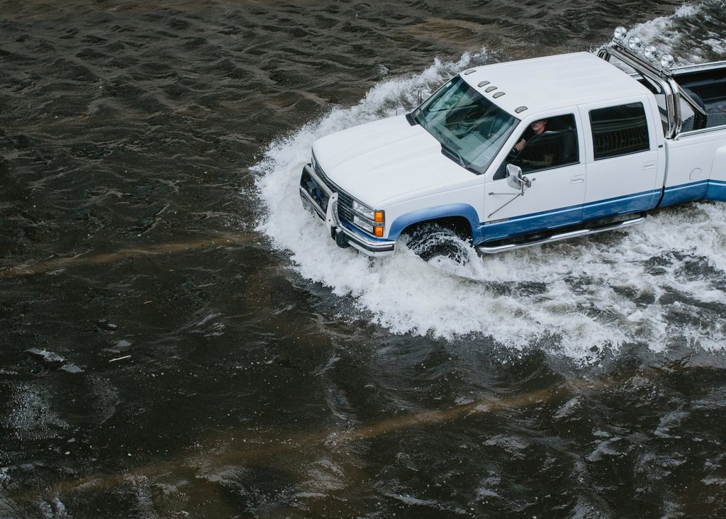 positive climate action car driving through flood