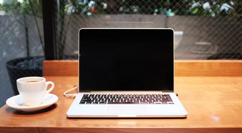 alex-knight-j4uuKnN43_M-unsplash image of computer with a cup of coffee. Ready for the whole team to watch netflix