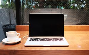 image of computer with a cup of coffee. Ready for the whole team to watch netflix