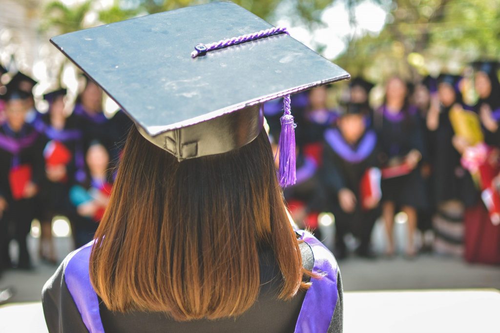 Young woman graduating from an education centre wearing a graduation gown and hat