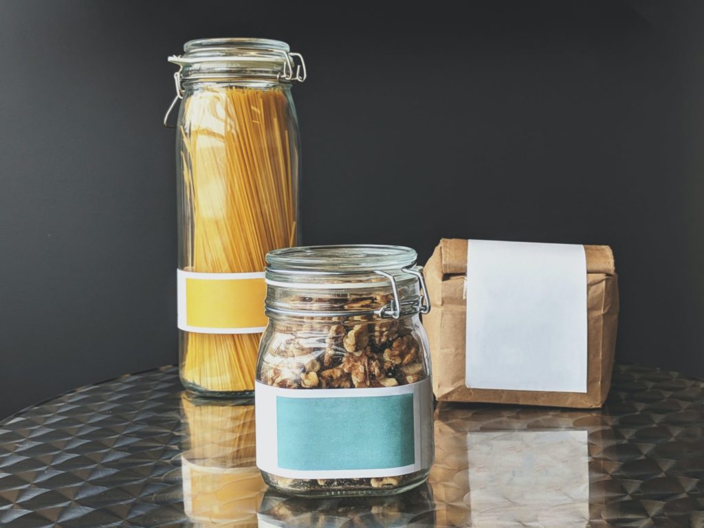 Zero waste packaged items. A jar of pasta. A jar of nuts. A paper bag of flour. Highlighting the move to low waste as a great way of reducing waste, key to this united nations sustainable development goal