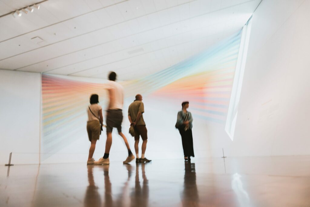 An image of a small group of people enjoying a piece of work at a museum. The photo is distorted slightly to represent key themes of the work the people are viewing.