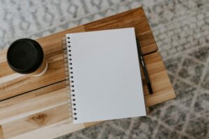 quality education blog post cover. A blank notebook on a wooden table with a coffee cup